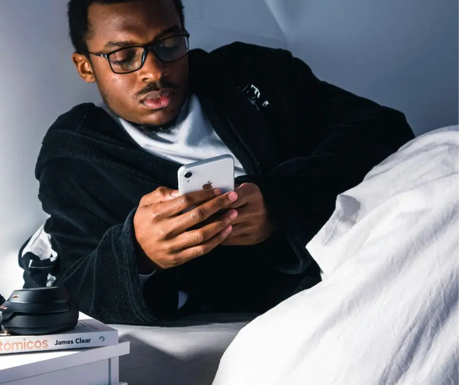 man struggling to sleep because of phone use